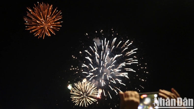 People capture the radiant fireworks display in the night sky. People capture the radiant fireworks display in the night sky.