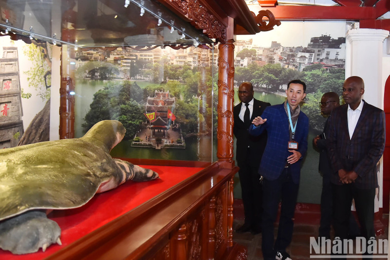 Togolese Foreign Minister Robert Dusse listens to an introduction to the Hoan Kiem Lake turtle specimen at the Ngoc Son Temple exhibition house.