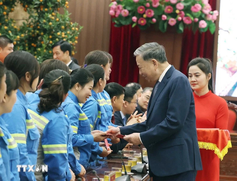 Party General Secretary To Lam gives li xi (lucky money) to workers. (Photo: Thong Nhat/VNA) Party General Secretary To Lam gives li xi (lucky money) to workers. (Photo: Thong Nhat/VNA)