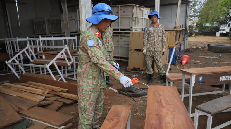 A member of Viet Nam’s Engineering Unit Rotation 3 fabricates a student desk-bench set from repurposed materials. A member of Viet Nam’s Engineering Unit Rotation 3 fabricates a student desk-bench set from repurposed materials.