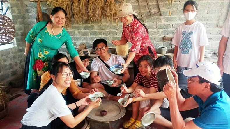 Generations gather joyfully around the model of a traditional Vietnamese family meal.