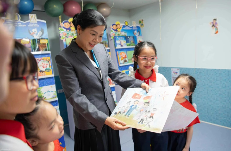 The children proudly show their drawings to Ngo Phuong Ly.