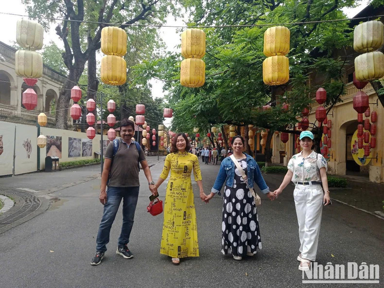 International and Vietnamese tourists take a group photo at the Thang Long Imperial Citadel. (Photo HA THANH) International and Vietnamese tourists take a group photo at the Thang Long Imperial Citadel. (Photo HA THANH)