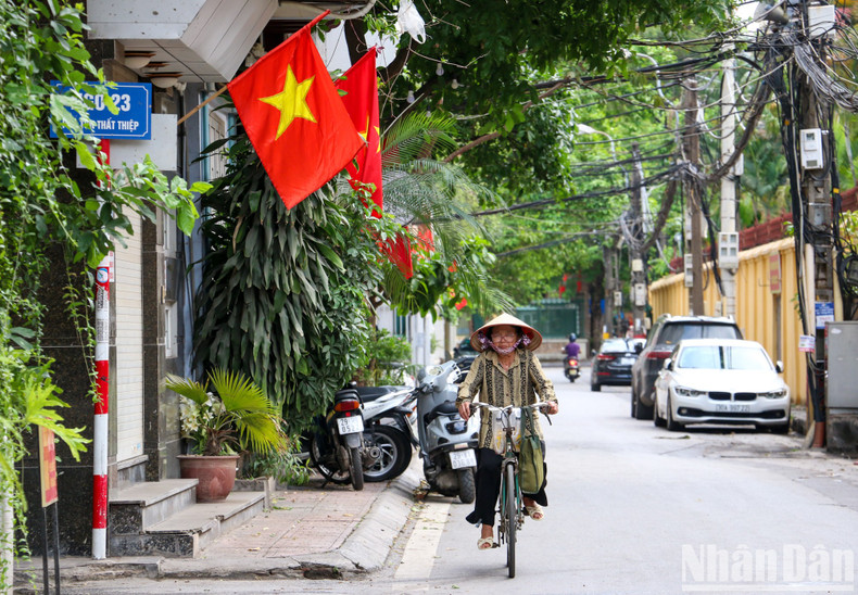In the small alleys of Hanoi, households hang the national flag.
