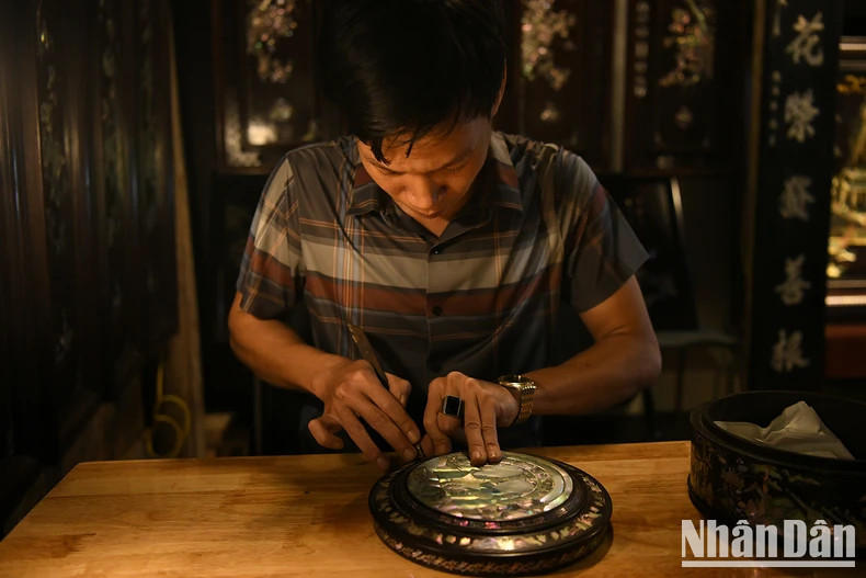 An artisan cutting mother-of-pearl and shell - the raw materials for mother-of-pearl inlay artwork An artisan cutting mother-of-pearl and shell - the raw materials for mother-of-pearl inlay artwork