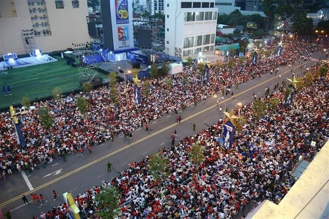 Thousands of people gather on Le Loi Street in Ho Chi Minh City's district 1 to watch the parade. (Photo: VNA)