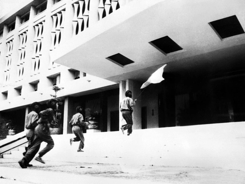At 11:30 am on April 30, 1975, soldier Bui Quang Than (holding the flag, front) and three other soldiers of Army Corps 2 — the Hương Giang Corps — raised the Liberation Flag atop the Presidential Palace in Saigon. At 11:30 am on April 30, 1975, soldier Bui Quang Than (holding the flag, front) and three other soldiers of Army Corps 2 — the Hương Giang Corps — raised the Liberation Flag atop the Presidential Palace in Saigon.