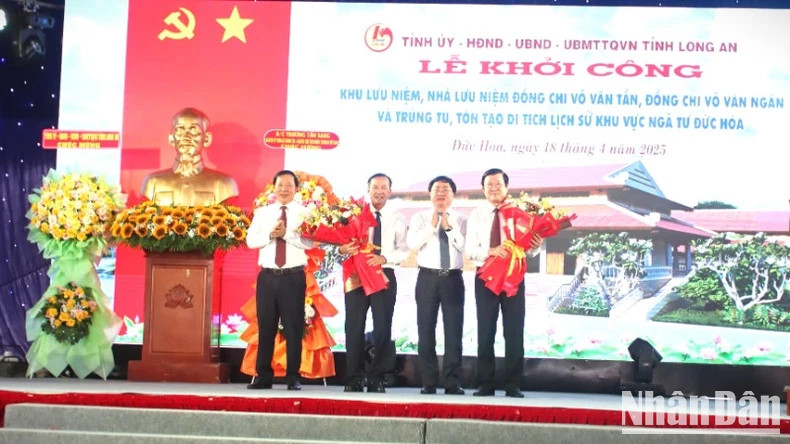 Secretary of Long An Provincial Party Committee Nguyen Van Quyet (second from right) and Chairman of Long An Provincial People's Committee (first from left) present flowers to former President Truong Tan Sang and the sponsor.