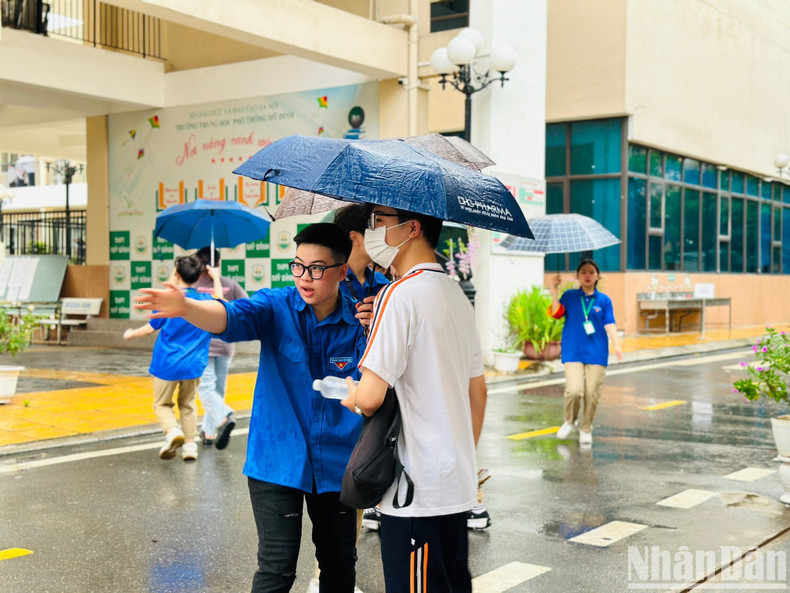 A volunteer gives instruction to a candidate on the way to the exam venue. A volunteer gives instruction to a candidate on the way to the exam venue.