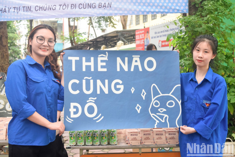 Two volunteers hold a slogan saying ‘You will surely pass the exam’ to encourage the candidates. Two volunteers hold a slogan saying ‘You will surely pass the exam’ to encourage the candidates.