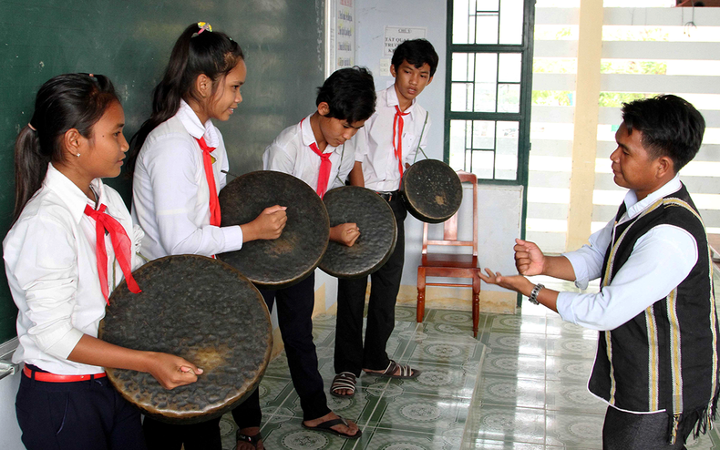 An artisan teaches Raglai ethnic students how to play the gongs (Photo: Nguyen Trung)
