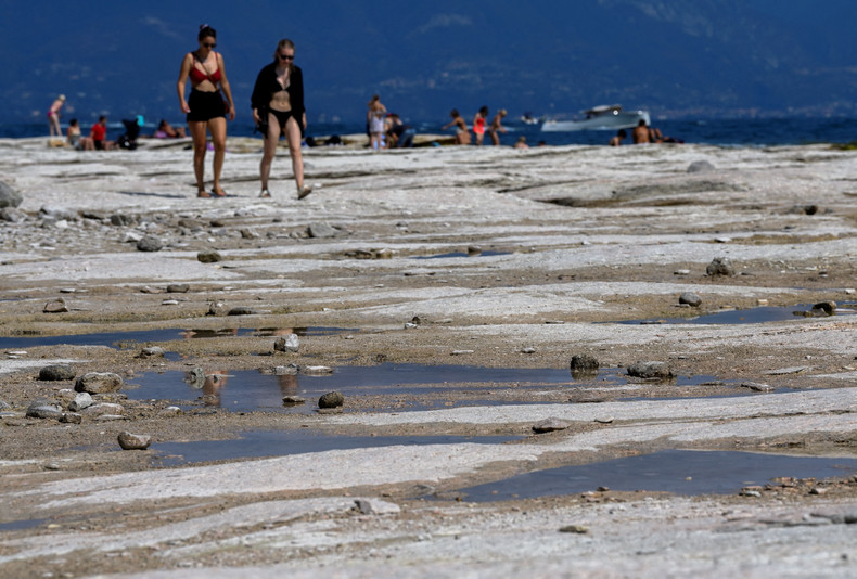 People walk as underwater rocks emerge from the water of Lake Garda after northern Italy experienced the worst drought in 70 years in Sirmione, Italy, August 16, 2022. (Photo: Reuters) People walk as underwater rocks emerge from the water of Lake Garda after northern Italy experienced the worst drought in 70 years in Sirmione, Italy, August 16, 2022. (Photo: Reuters)