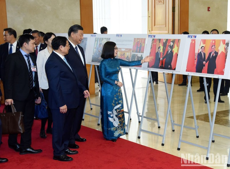 Prime Minister Pham Minh Chinh (R) and Chinese Party General Secretary and President Xi Jinping admire photos highlighting the relationships between the two countries. Prime Minister Pham Minh Chinh (R) and Chinese Party General Secretary and President Xi Jinping admire photos highlighting the relationships between the two countries.