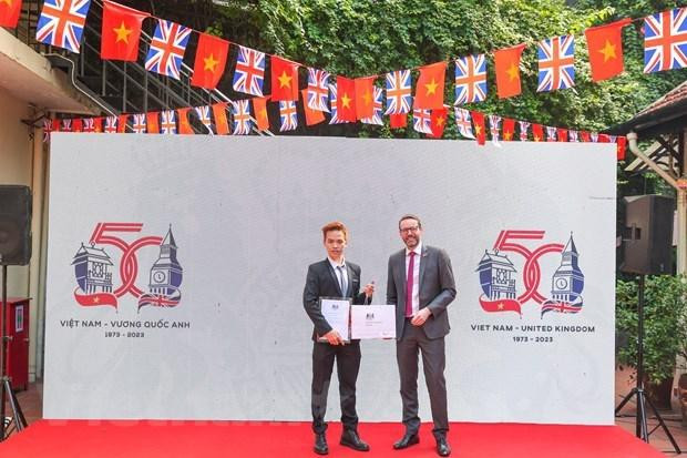 British Ambassador to Vietnam Iain Frew (right) presents the insignia to Ngo Quang Trung, the winner of the contest. (Photo: Vietnam Plus)