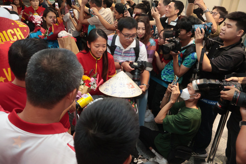 Huynh Nhu and her teammates surrounded by the press and fans. Huynh Nhu and her teammates surrounded by the press and fans.