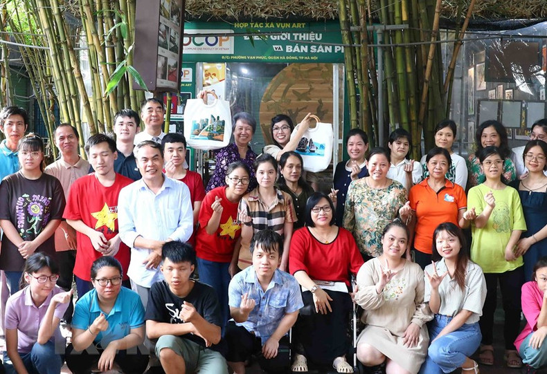 Le Thi Bich Tran (right), the spouse of Prime Minister Pham Minh Chinh, and Ho Ching, the spouse of Singapore's Prime Minister Lee Hsien Loong, take souvenir photos with members of the Vun Art Cooperative. Le Thi Bich Tran (right), the spouse of Prime Minister Pham Minh Chinh, and Ho Ching, the spouse of Singapore's Prime Minister Lee Hsien Loong, take souvenir photos with members of the Vun Art Cooperative.