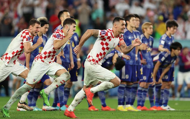 Croatia's Dejan Lovren and Josko Gvardiol celebrate qualifying for the quarter finals as Japan players looks dejected after being eliminated from the World Cup. REUTERS/Marko Djurica