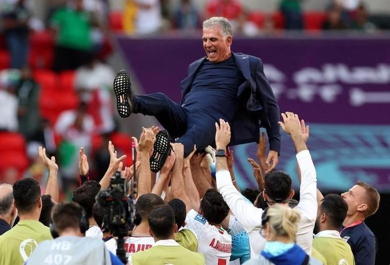 Iran coach Carlos Queiroz celebrates with the players after the match. REUTERS/Amanda Perobelli