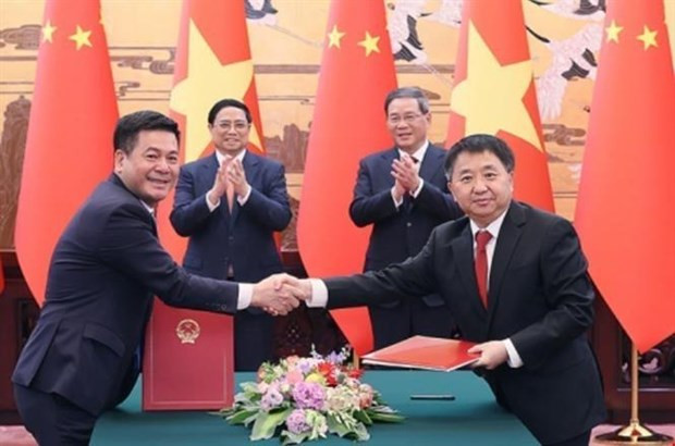 Vietnamese Prime Minister Pham Minh Chinh (second row, left) and Chinese Premier Li Qiang (second row, right) witness the signing and announcement of four cooperation documents between ministries, sectors and localities of the two countries. (Photo: VNA)