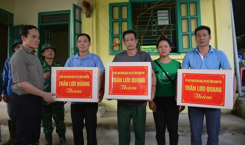 Deputy Prime Minister Tran Luu Quang presents gifts to support families affected by flash floods.