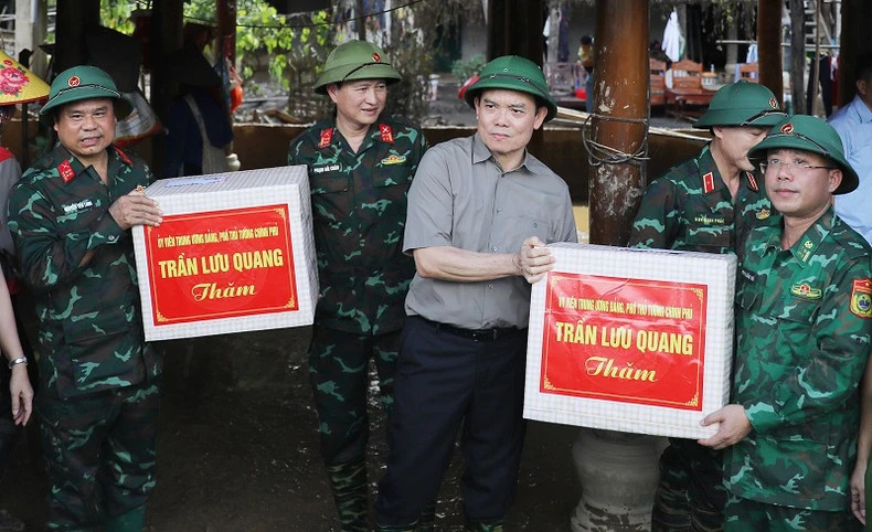 Deputy Prime Minister Tran Luu Quang presents gifts and encourages officers and soldiers of units who have made efforts to help people in the Muong Pon flash flood area.