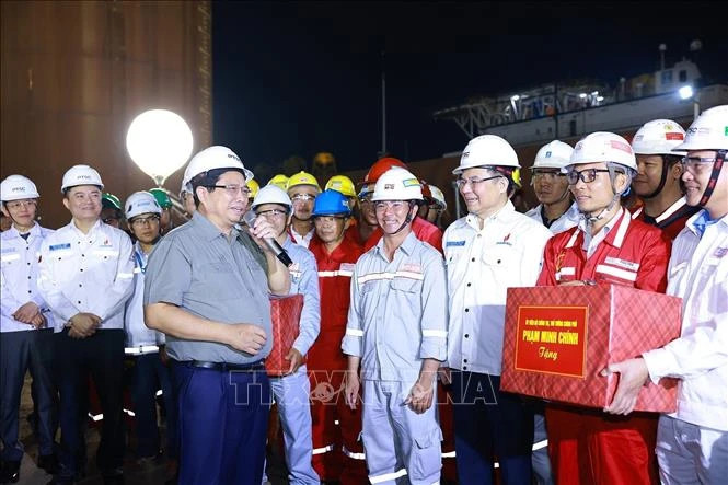 Prime Minister Pham Minh Chinh with engineers and workers of the PTSC Centre for Energy Industry and Port Logistics Services. (Photo: Duong Giang/VNA)