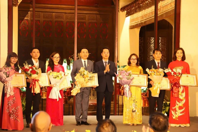 Hoan Kiem District Party Secretary Vu Dang Dinh presents awards to collectives and individuals who have contributed to preserving and promoting the value of Hanoi's Old Quarter.