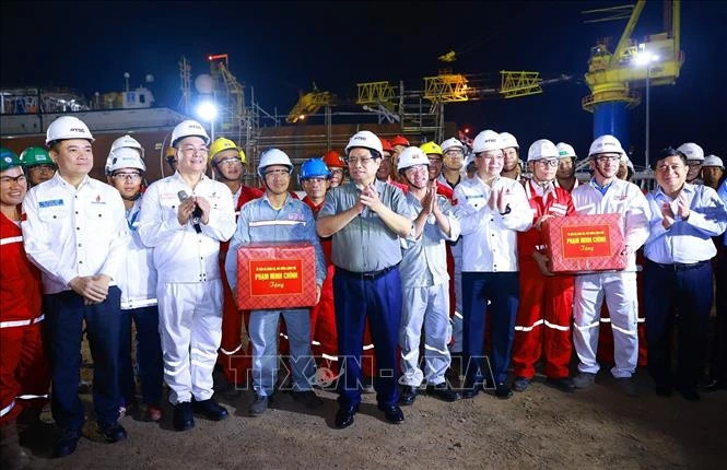 Prime Minister Pham Minh Chinh presents gifts to engineers and workers of the PTSC Centre for Energy Industry and Port Logistics Services. (Photo: Duong Giang/VNA)