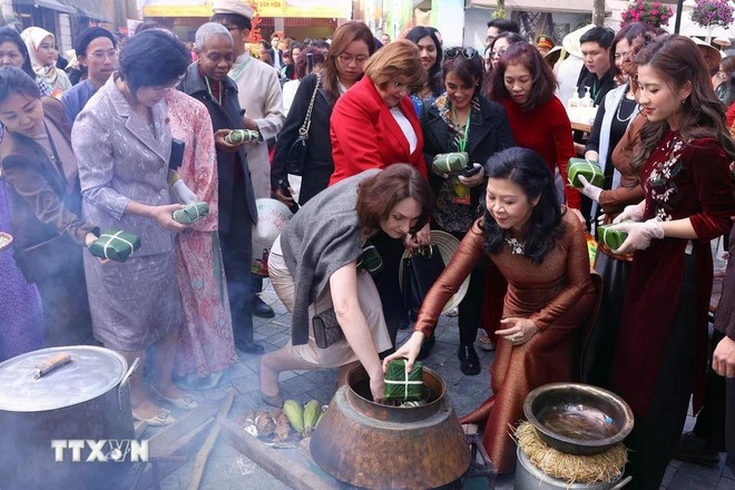 Spouse of the Party General Secretary Ngo Phuong Ly and foreign female diplomats cook 'banh chung' (Photo: VNA)