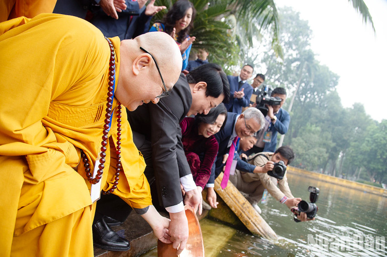Delegates perform the carp release ritual.