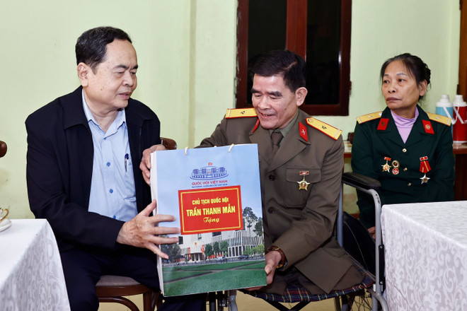 NA Chairman Tran Thanh Man presents a gift to Nguyen Trong Hung – a war veteran classified as 1/4 disabled - in Yen Bai province on January 4. (Photo: VNA)