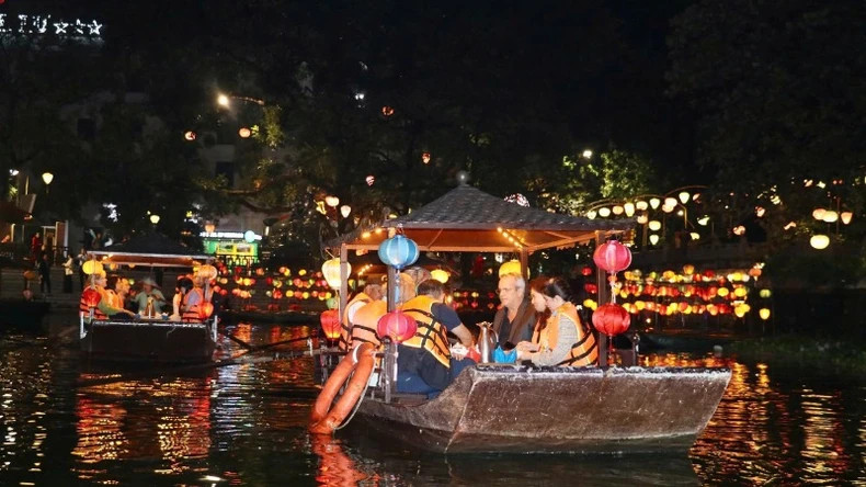 Delegates experience boating in the middle of Ky Lan Lake, admiring the sparkling beauty of Hoa Lu walking street and Tu An Tower at night.