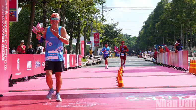 An athlete carries a bouquet of lotus during the run to promote the image of Dong Thap – the land of lotuses.