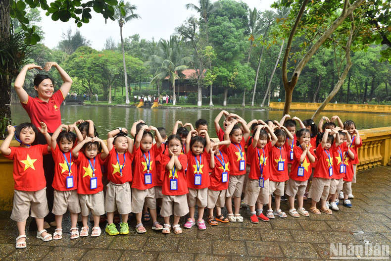 Children pose for a group photo in front of the pond.