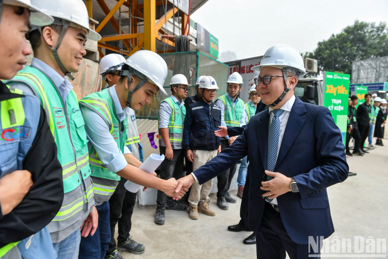 Editor-in-Chief of Nhan Dan Newspaper Le Quoc Minh and engineers and workers at the event.