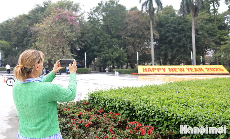 A foreigner takes a photo of a floral decoration reading ‘Happy New Year 2025’ A foreigner takes a photo of a floral decoration reading ‘Happy New Year 2025’
