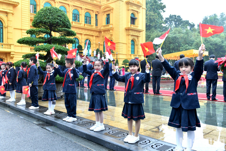 Hanoi children wave national flags of Vietnam and Indonesia to welcome Indonesian President Joko Widodo.
