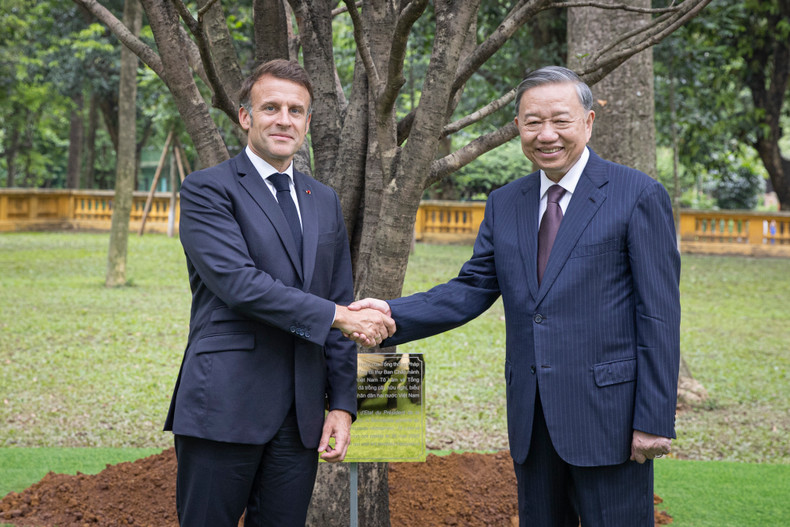 Party General Secretary To Lam (R) and French President Emmanuel Macron plant a friendship tree at the President Ho Chi Minh relic site (Photo: NDO)