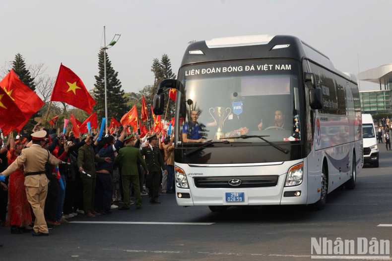 Forward Tien Linh sat at the front of the bus with the ASEAN Cup trophy.