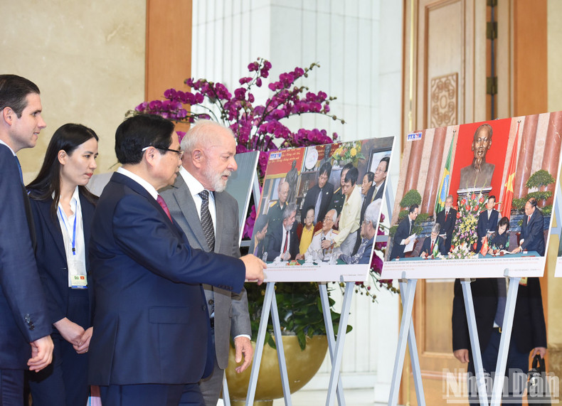 Prime Minister Pham Minh Chinh and Brazilian President Luiz Inacio Lula da Silva visit a photo exhibition on the two countries' cooperation on the sidelines of their meeting in Hanoi on March 28. (Photo: NDO/Tran Hai)