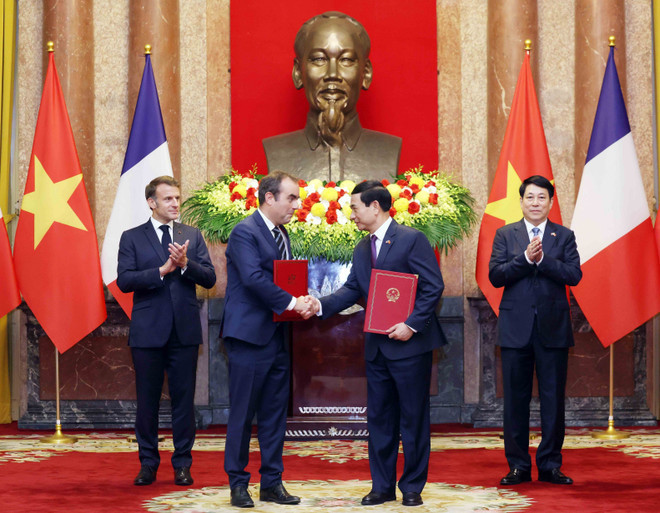 Vietnamese Minister of National Defence Phan Van Giang (second from right) and French Minister of the Armed Forces Sebastien Lecornu exchange a letter of intent between the two ministries on enhancing cooperation in the field of defence equipment. (Photo: VNA)