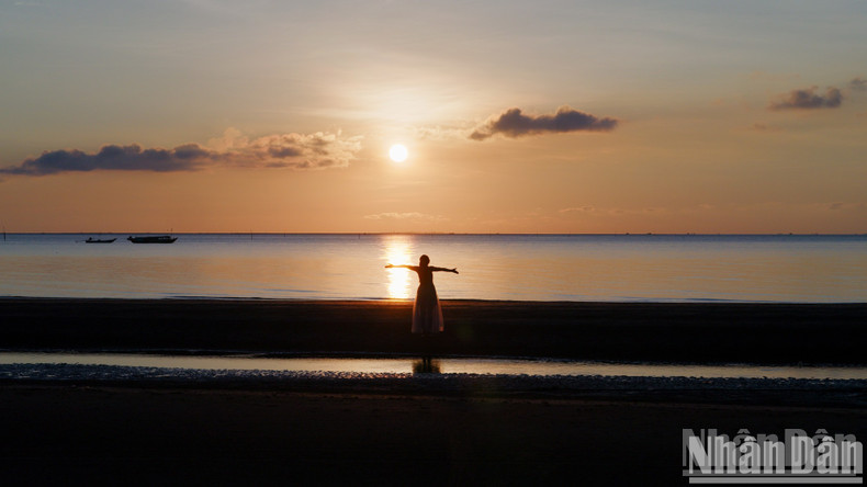 Tourists enjoy the moment of dawn at Ba Dong Beach Tourists enjoy the moment of dawn at Ba Dong Beach