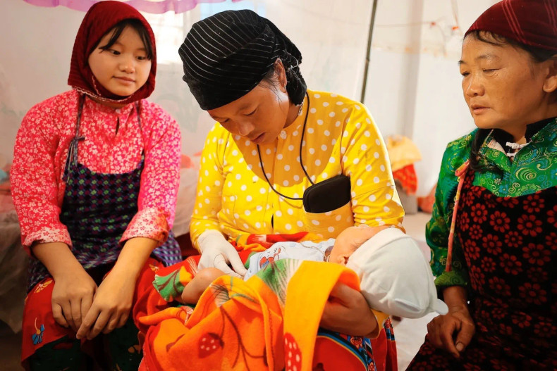 A midwife cares for a newborn at home in Cang Tang Village, Lung Cu Commune, Dong Van District, Ha Giang Province. (Photo: VNA) A midwife cares for a newborn at home in Cang Tang Village, Lung Cu Commune, Dong Van District, Ha Giang Province. (Photo: VNA)