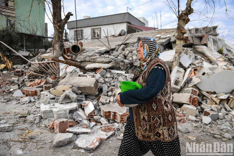 A woman brings water and food to the tent. In the background are the ruins of the old town of Nurdagi. Her eyes couldn't hide the worry. A woman brings water and food to the tent. In the background are the ruins of the old town of Nurdagi. Her eyes couldn't hide the worry.