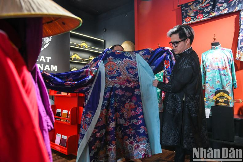 Vu Duc next to a model of ancient costume that was painstakingly restored.