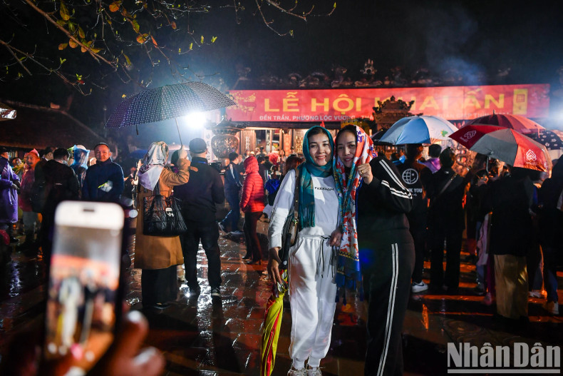 Two female tourists take a photo of this year's opening ceremony at Tran Temple. Two female tourists take a photo of this year's opening ceremony at Tran Temple.