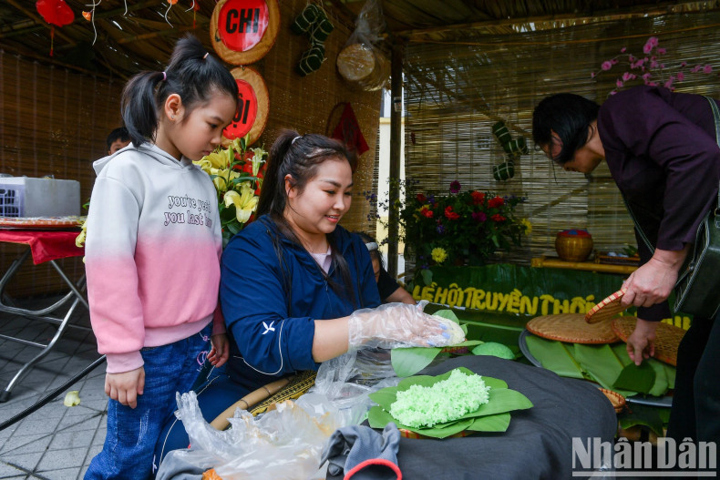 A child showed interest in traditional sticky rice from a thousand-year-old village along the Red River.