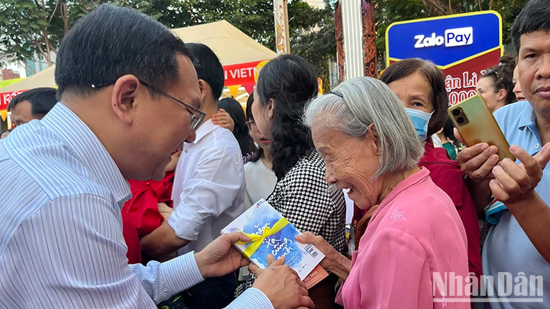 Director of the municipal Department of Information and Communications, Lam Dinh Thang, offers books to tourists as Tet gifts. Director of the municipal Department of Information and Communications, Lam Dinh Thang, offers books to tourists as Tet gifts.