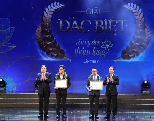 President Vo Van Thuong (first, right) and Standing Vice Chairman of the National Assembly Tran Thanh Man (first, left) present awards to winners of the sixth “Unsung Sacrifice” writing contest at the programme. (Photo: VNA)