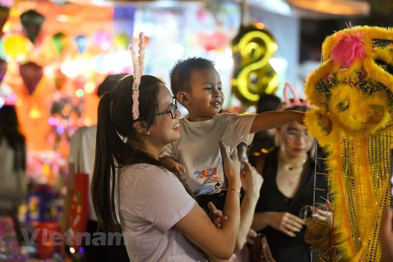 It is not difficult to see the image of a child in the arms of his parents in the middle of a "sea of people" going out to play during the Mid-Autumn Festival.